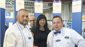 Małgorzata Rucińska, Marketing Manager w Grupie Polmlek w otoczeniu kucharzy przygotowujących smakowitości z produktów Polmlek